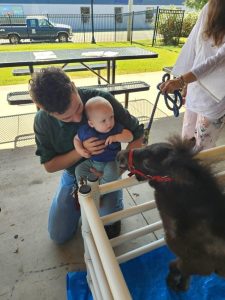 Abraham and his dad Jonathan petting Junebug, one of the three MESH (Minicamolot Emotional Support Horses), during the school early release day Jamerson Library’s Pet a Mini Horse afternoon.